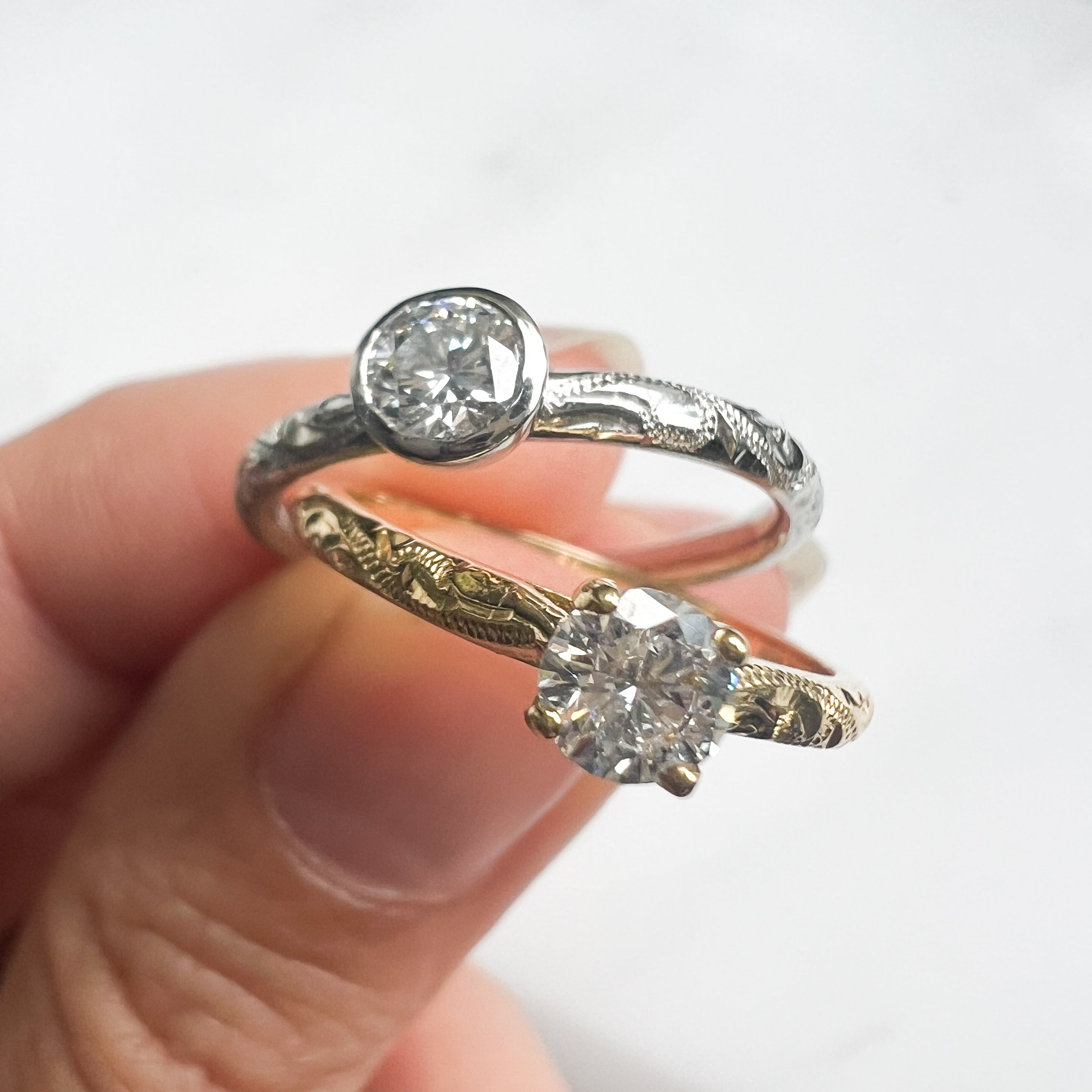 Two diamond rings held together against a white background