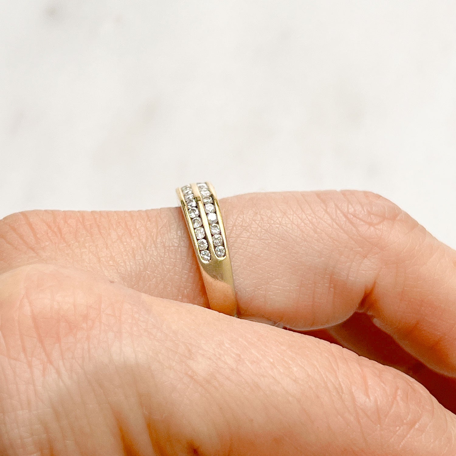 Reclaimed Vintage commitment ring with two antique Victorian half diamond eternity rings, on hand, side view