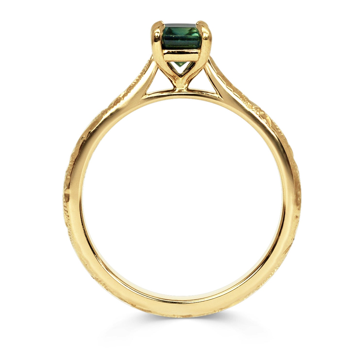 18ct recycled gold solitaire engagement ring with a baguette teal sapphire in a classic solitaire claw setting and a hand engraved band, side view