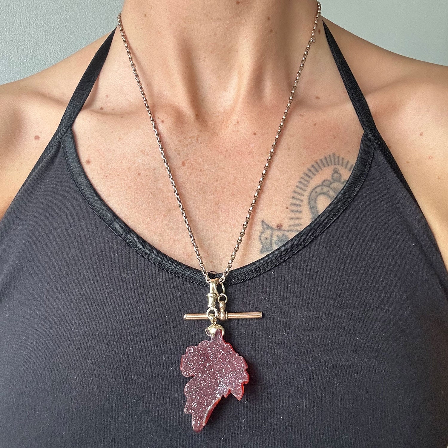 Reclaimed Vintage necklace with a red leaf-shaped carnelian quartz pendant, reclaimed antique Victorian gold chain and T-bar clasp, modelled on body