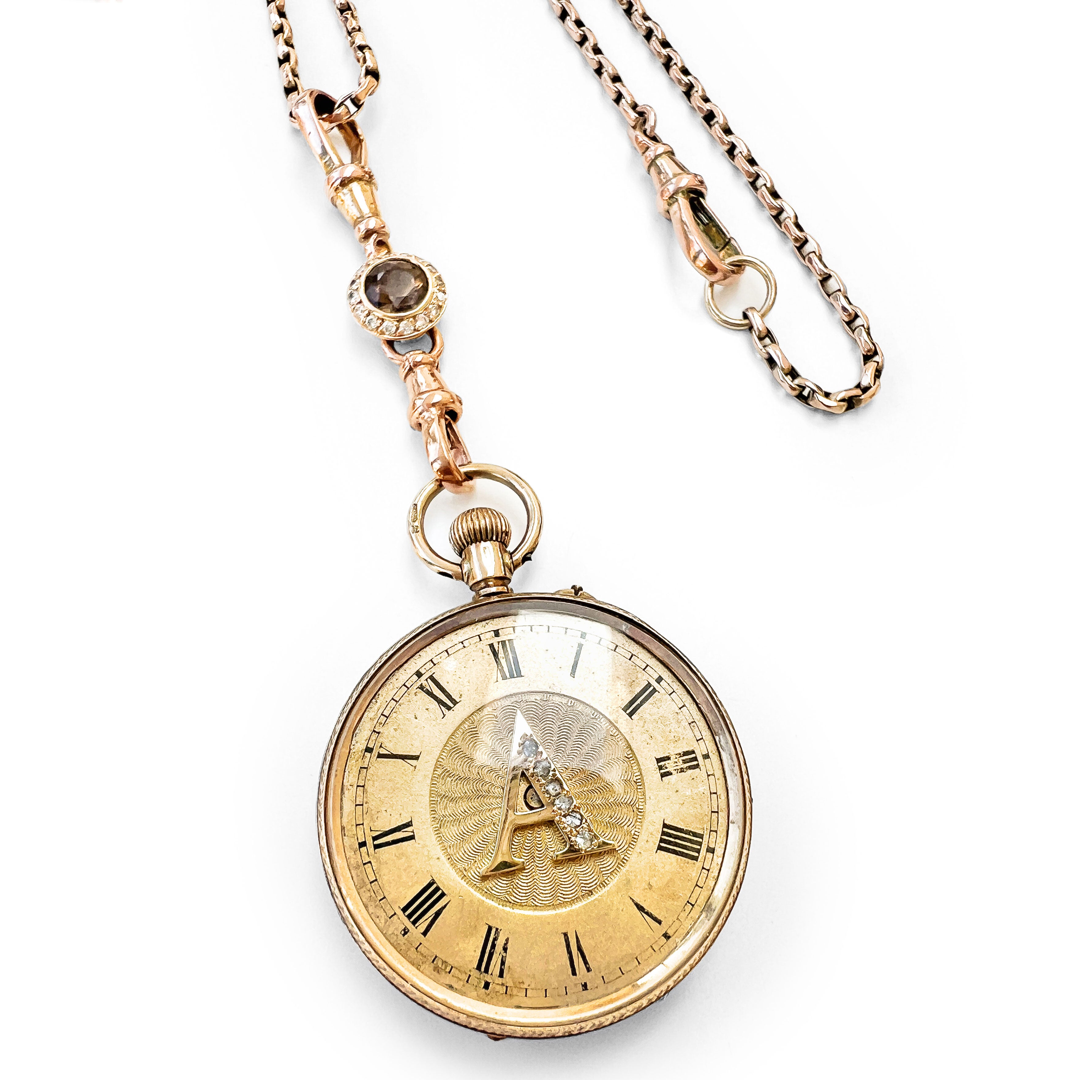 Reclaimed Vintage antique Victotrian pocket watch with Roman numerals and a decorative 'A', set with broken diamonds - repurposed as a pendant on a reclaimed antique gold chain and Albert clasp - on a white background, V4