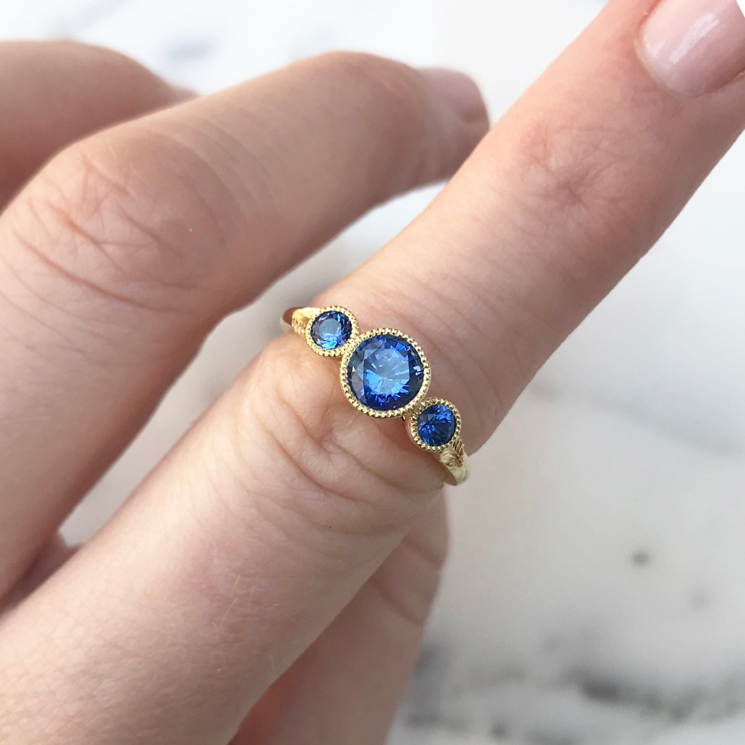 Bespoke ethical sapphire trilogy engagement ring, 18ct recycled yellow gold and traceable Sri Lankan sapphires lifestyle 2