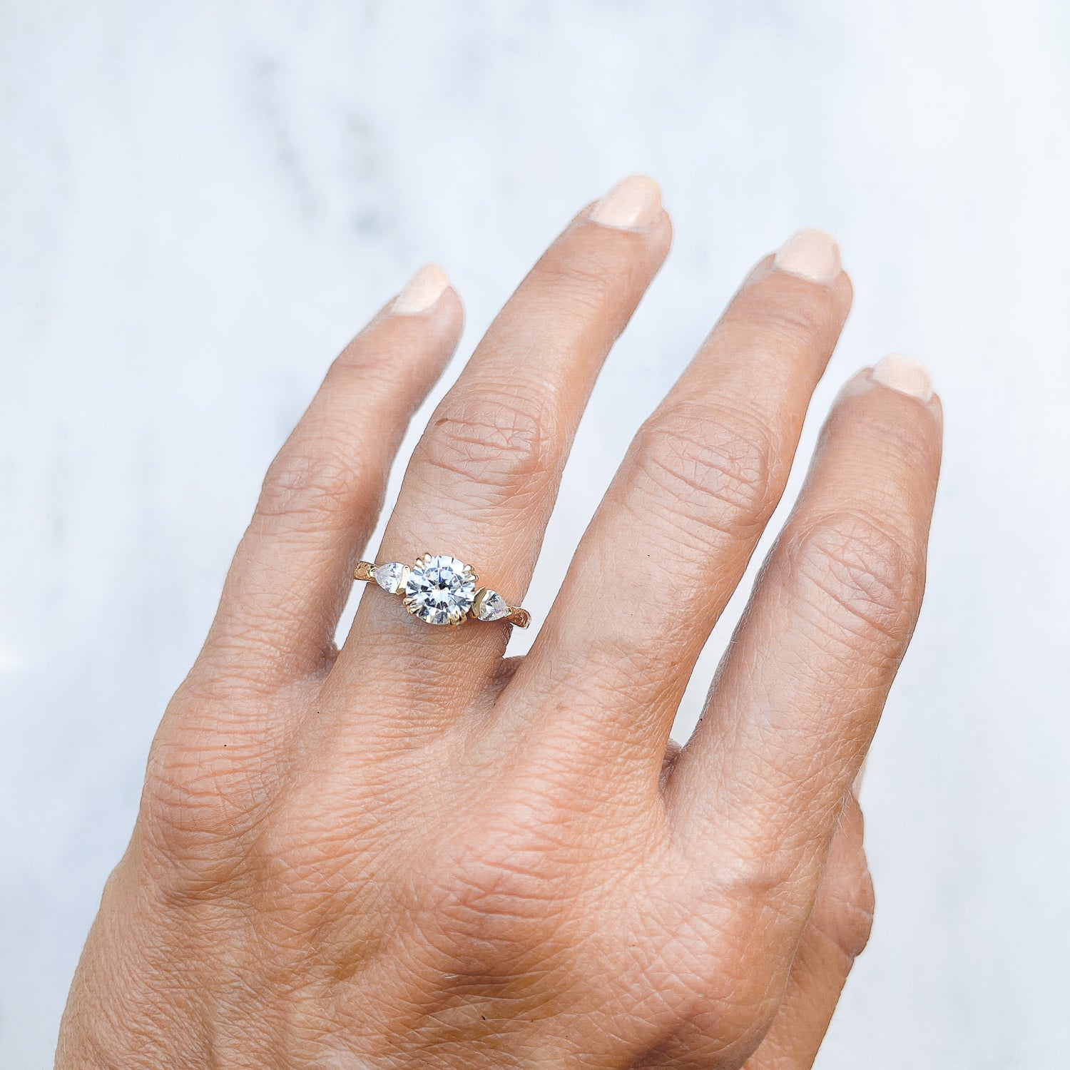 Lebrusan Studio Artisan Trilogy Engagement Ring, 1ct Ocean Diamond, 0.3ct pear-cut side Ocean Diamonds, 18ct Fairmined Ecological Gold, hand engraving, on hand