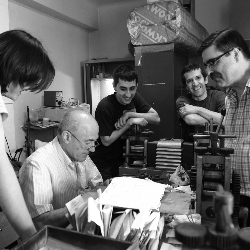 Master filigree artisan Lorenzo busy at work in his filigree workshop, surrounded by family members