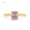 Fancy Athena ethical solitaire engagement ring in 18ct yellow Fairtrade Gold, hand-engraved and set with a pink emerald-cut sapphire of traceable and fair-traded Sri Lankan provenance