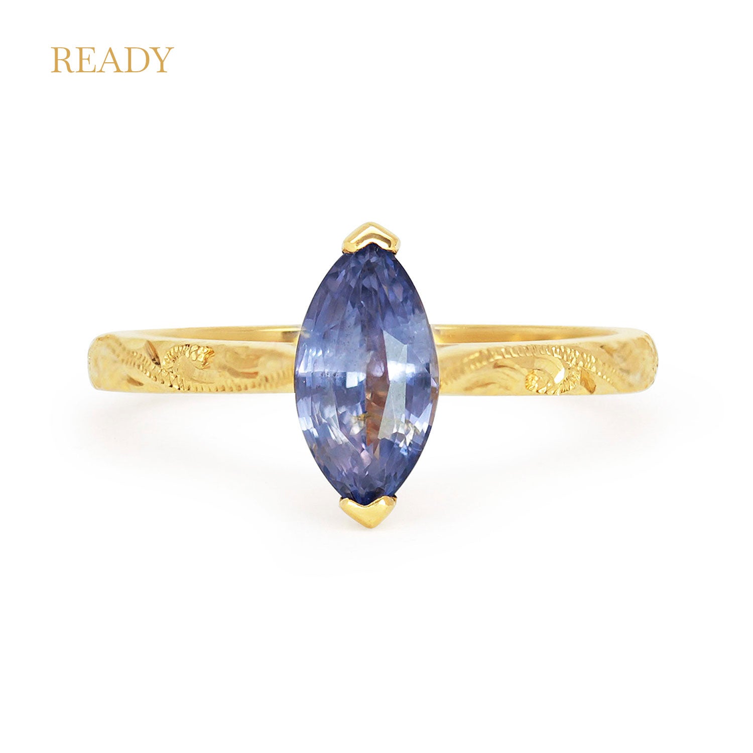 Fancy Athena ethical solitaire engagement ring in 18ct yellow Fairtrade Gold, hand-engraved and set with a blue marquise sapphire of fair-traded and traceable Sri Lankan provenance