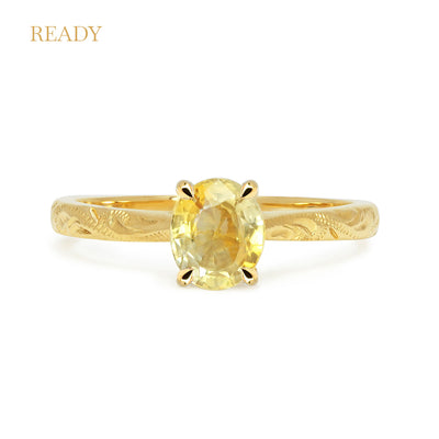 Fancy Athena ethical solitaire engagement ring in 18ct recycled yellow gold, hand-engraved and set with a yellow oval-cut sapphire of fair-traded and traceable Sri Lankan provenance