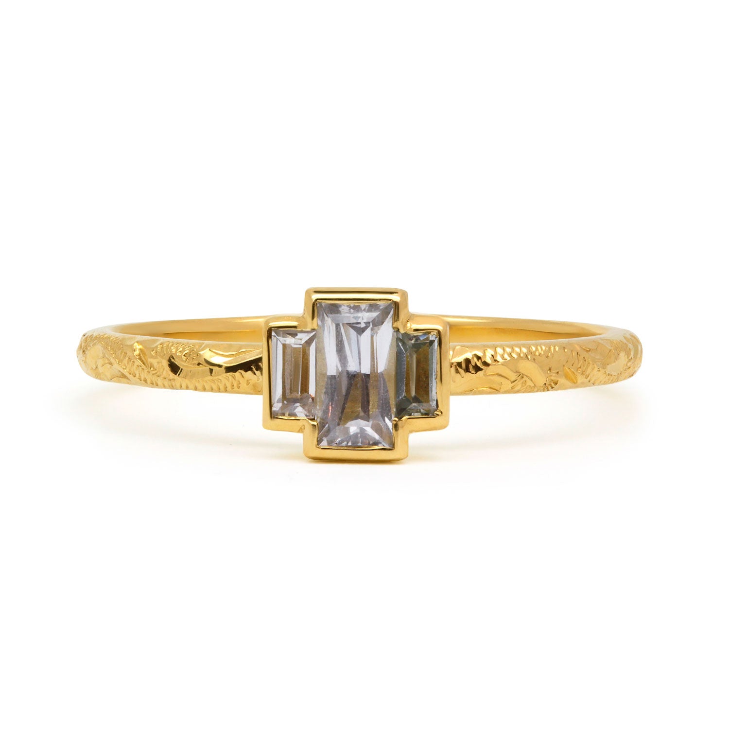Fancy Hera ethical trilogy engagement ring in 18ct recycled yellow gold, hand-engraved and set with three grey baguette sapphires of fair-traded and traceable Sri Lankan provenance