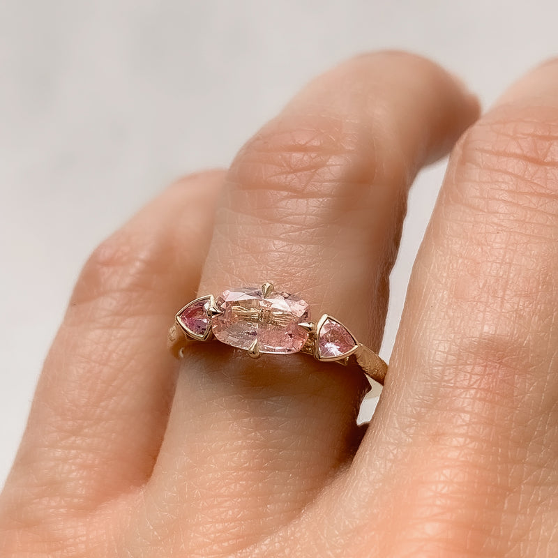 Lebrusan Studio Fancy Athena trilogy engagement ring with hand-engraved 18ct Fairmined Eco Gold, a cushion-cut pink sapphire and two trillion-cut pink sapphires