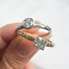 Two diamond rings held together against a white background