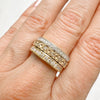 Three antique 9ct gold Victorian eternity rings half-set with diamonds, soldered together into a chunky stack, on hand