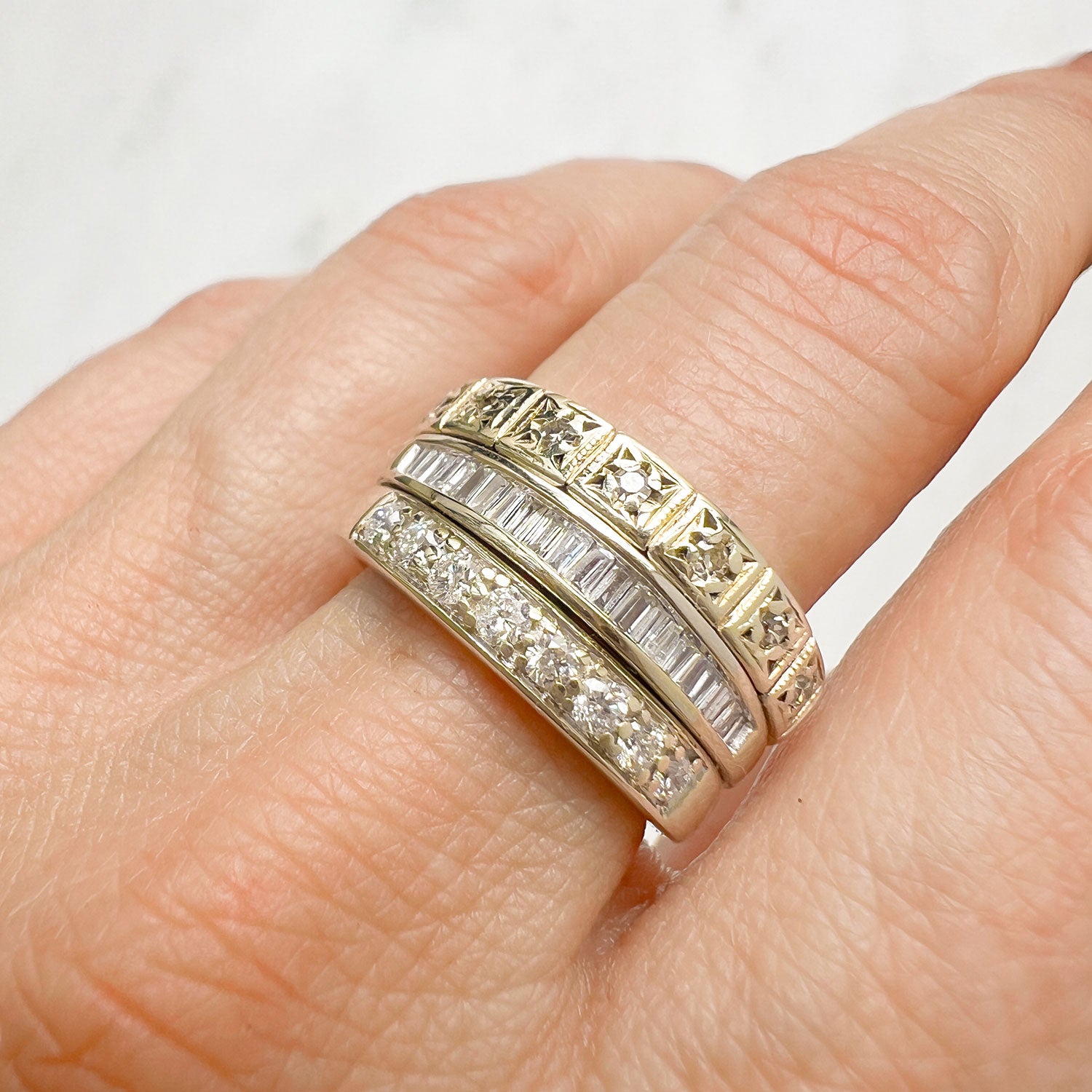 Reclaimed Vintage commitment ring with three reclaimed antique Victorian diamond eternity rings, on hand