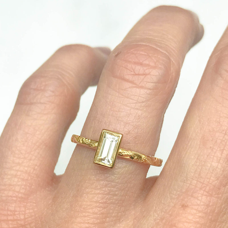 Fancy Hera ethical solitaire engagement ring in 18ct recycled yellow gold, hand-engraved and set with a recycled baguette diamonde