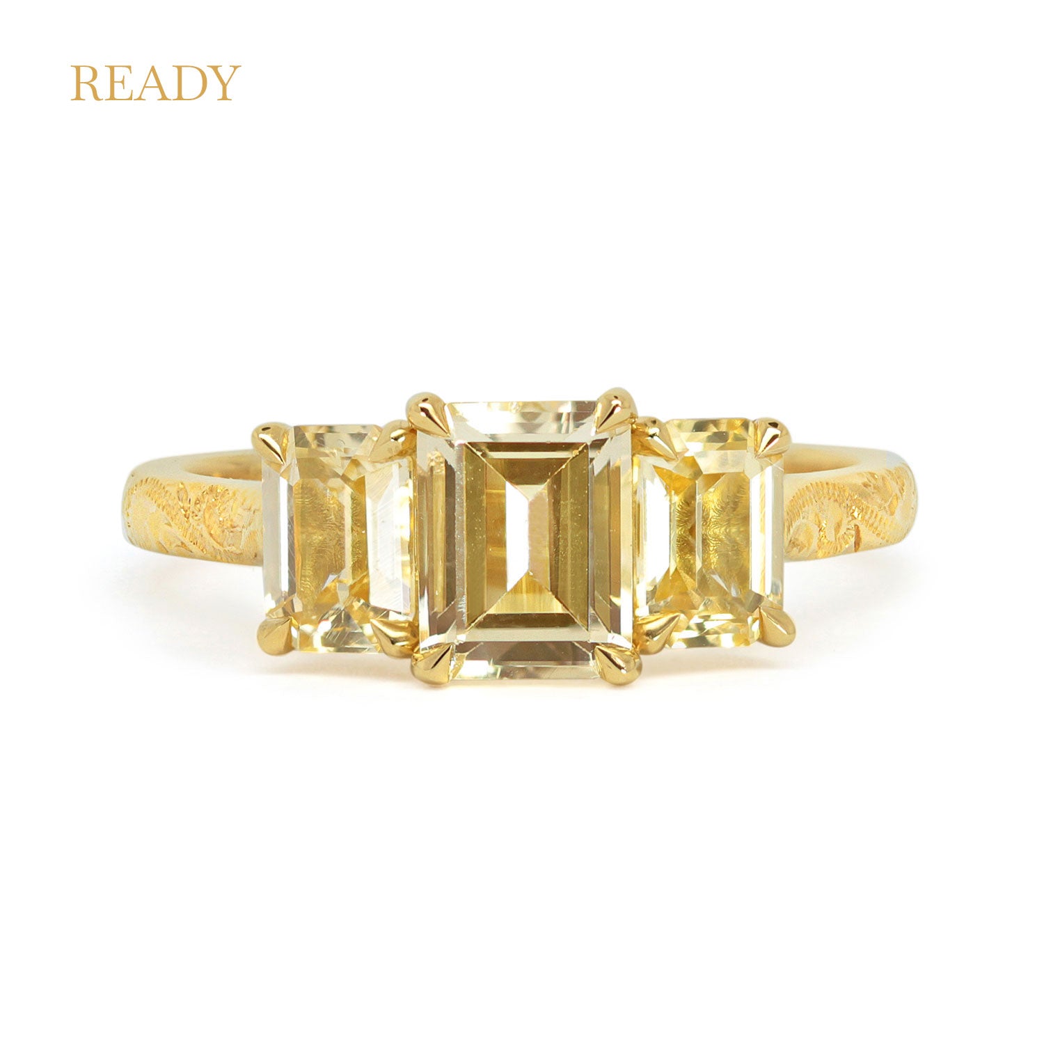 Lebrusan Studio Fancy Athena trilogy engagement ring with hand-engraved 18ct yellow Fairmined Eco Gold band and three emerald cut yellow sapphires of ethical traceable origin