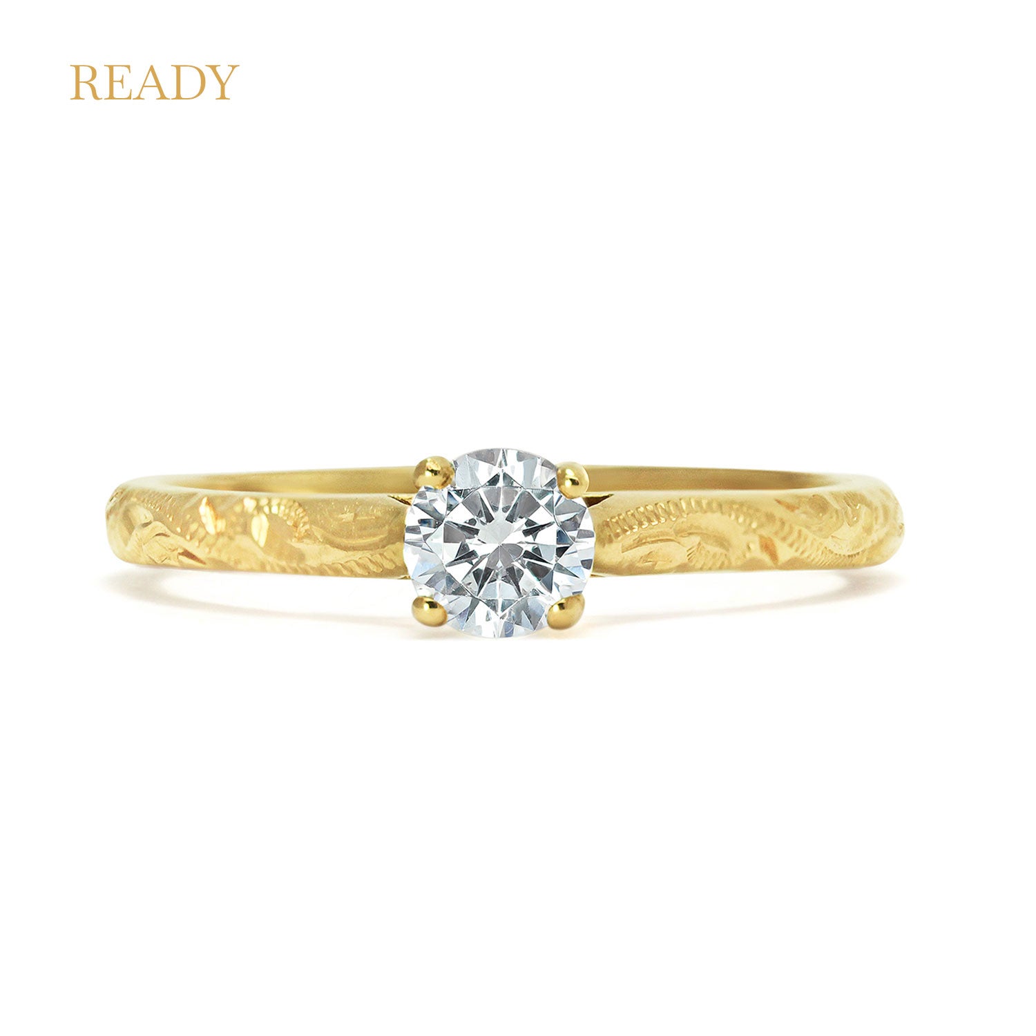 Solitaire engagement ring with a slim 18ct yellow gold band hand-engraved with intricate scrolls, and a 0.33ct round brilliant-cut diamond in a traditional four-claw setting