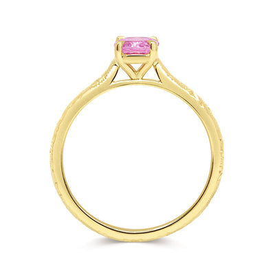 Solitaire engagement ring with a pink oval-cut fancy sapphire and an 18ct recycled eco gold band with hand engraving, side view