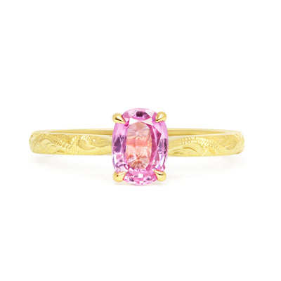 Solitaire engagement ring with a pink oval-cut fancy sapphire and an 18ct recycled eco gold band with hand engraving