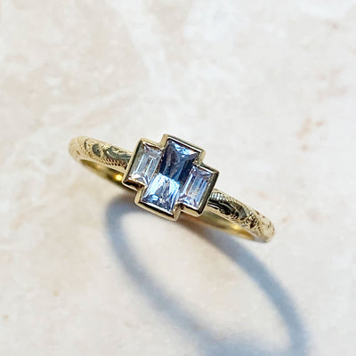 Lebrusan Studio's Candy Pop trilogy engagement ring with Sri Lankan baguette sapphires and a hand-engraved 18ct recycled gold band, lifestyle shot