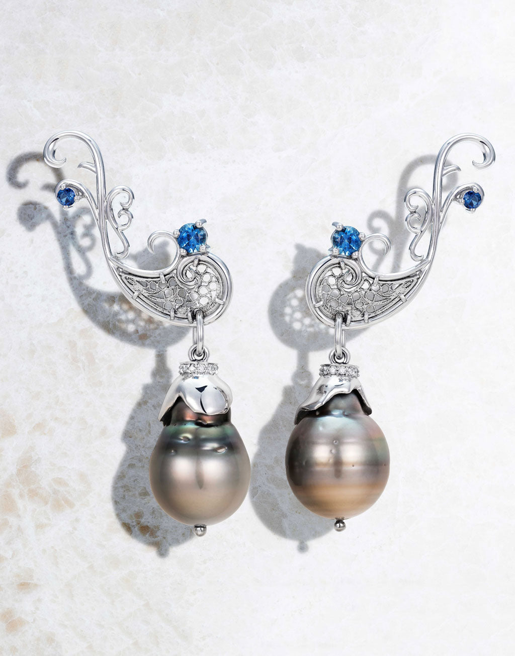 Highly hand-crafted filigree drop earrings holding sustainably harvested black Tahitian pearls and fair-traded tanzanite