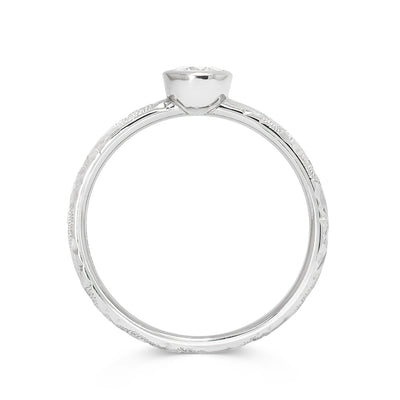 Solitaire 18ct white gold engagement ring with slim band hand-engraved with scrolls and a 0.33ct round brilliant-cut diamond in a rub-over setting, through view