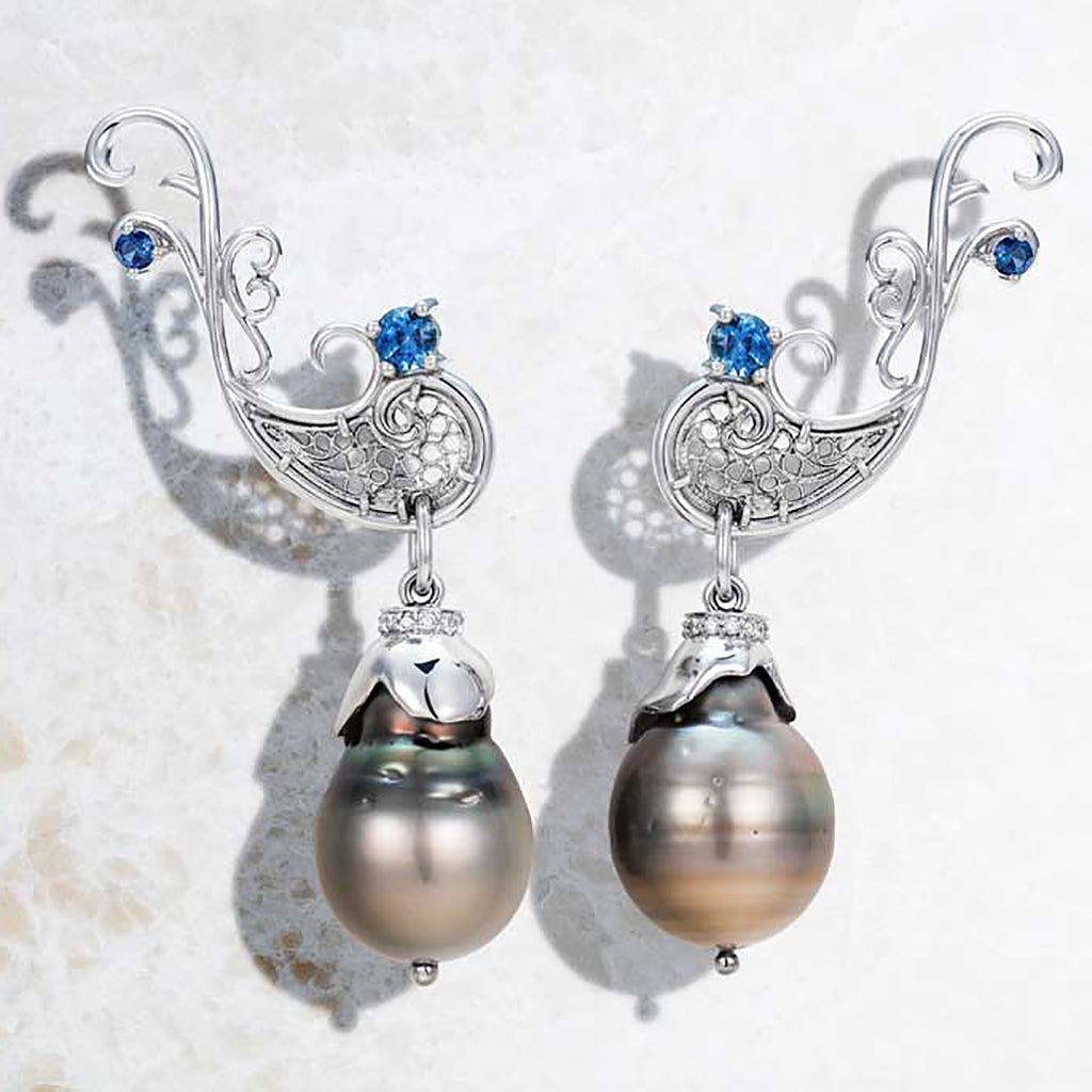 Bespoke earrings by London jewellery designer Arabel Lebrusan. Black eco-friendly Tahitian pearls are hung from 18ct white Fairtrade Gold frames, hand-crafted via the ancient Spanish filigree technique and set with traceable sapphires. Ethical jewelry UK