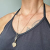 Reclaimed antique Victorian hand-engraved gold heart-shaped locket pendant necklace on a reclaimed antique gold chain, with a circlet connector in sustainable recycled gold and conflict-free Canadian diamonds, modelled on body 2