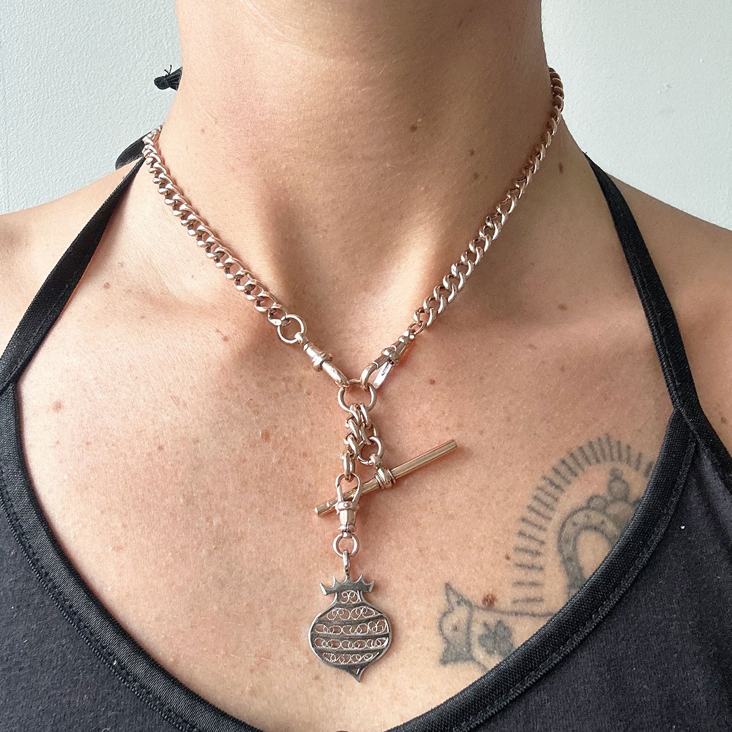 Unique necklace crafted using sustainable recycled rose gold, a repurposed antique Victorian T-bar clasp and a one-off hand-crafted filigree charm depicting a beehive, modelled on body 2