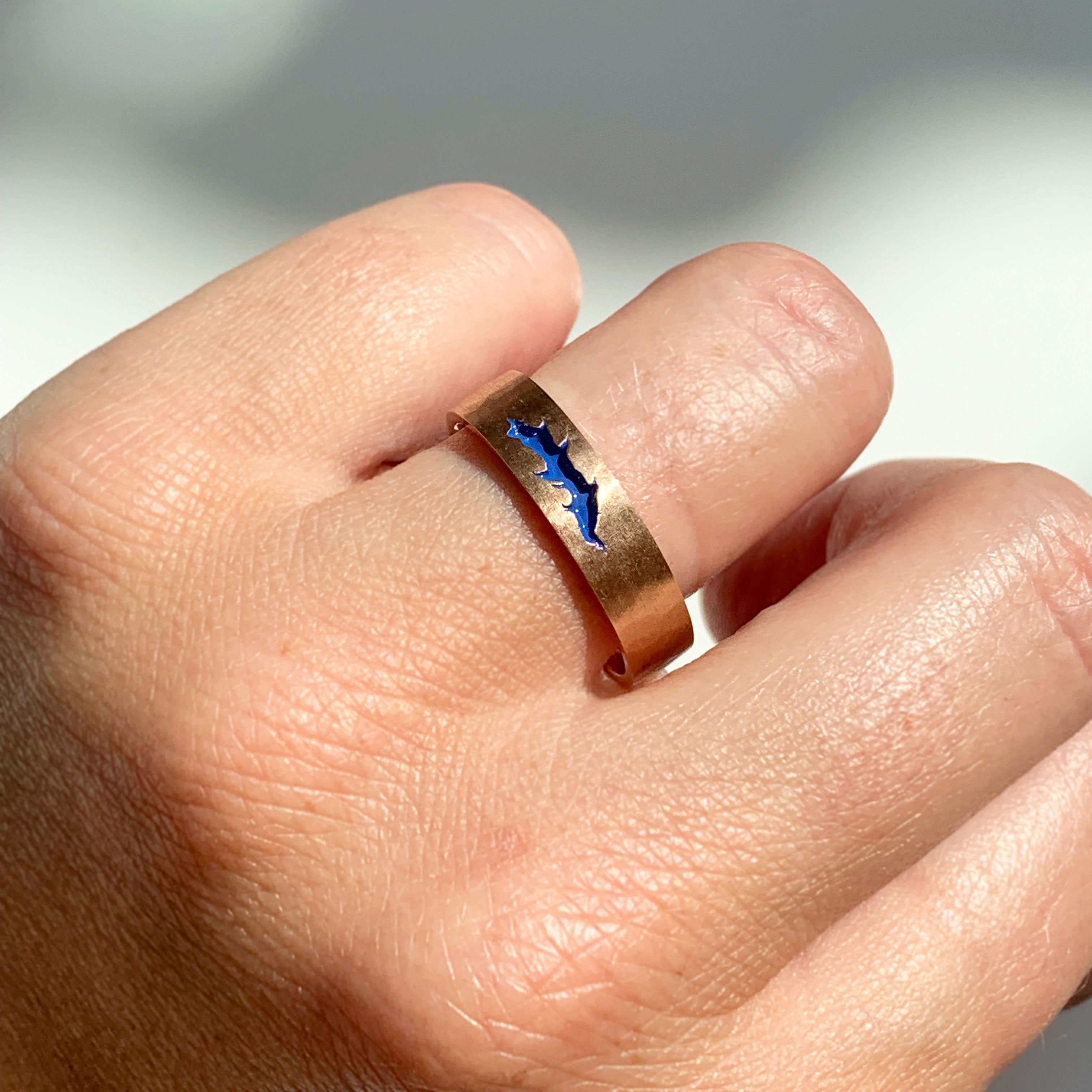 Bespoke flat court wedding band, finished with soft hammered and matte texture and a fissure inlayed with blue enamel. 9ct recycled rose gold reworked from an old heirloom piece. On hand, in the sunshine