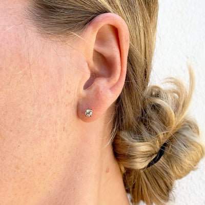 Lebrusan Studio rub-over stud earrings with milgrain beading - 18ct yellow Fairtrade Gold and 0.5ct of recycled diamonds, lifestyle photo on ear