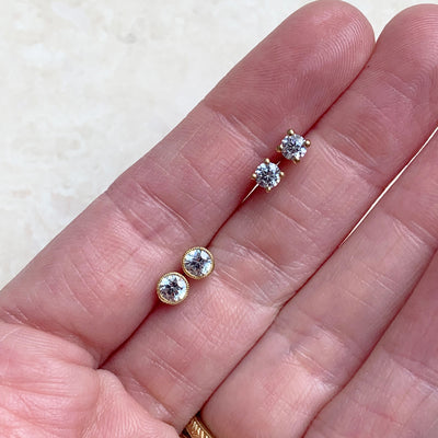 Lebrusan Studio rub-over stud earrings with milgrain beading - 18ct yellow Fairtrade Gold and 0.5ct of recycled diamonds, lifestyle photo on hand