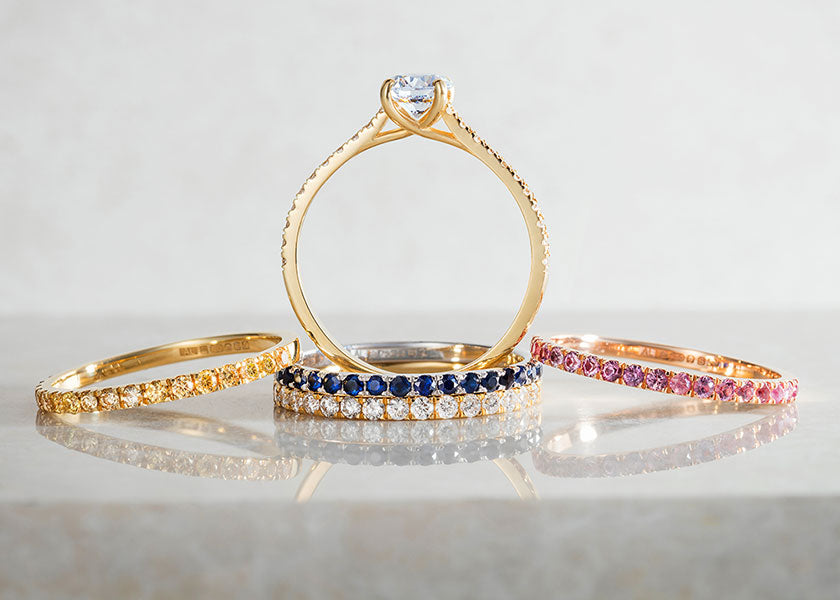 Lebrusan Studio's Altair collection of slender yellow gold wedding bands and commitment rings, microset with small conflict-free sapphires in yellow, blue, white and pink