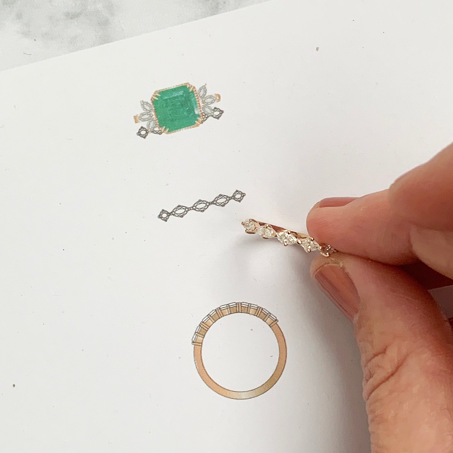 Bespoke 18ct recycled rose gold slim wedding band, claw-set with five inherited marquise diamonds and hand-engraved with scrolls, photographed with its design drawing and its matching bespoke engagement ring 