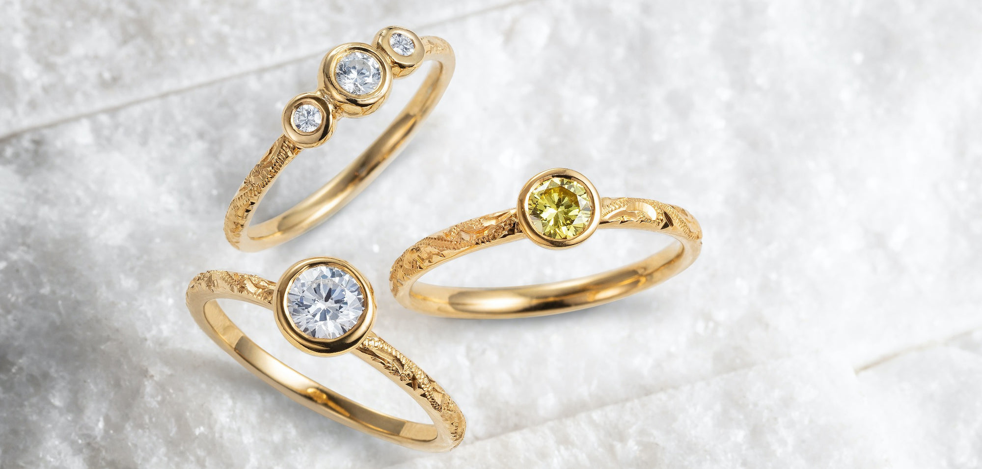 Engagement rings from our Hera collection, characterised by hand-engraved recycled gold bands and lab-grown diamonds