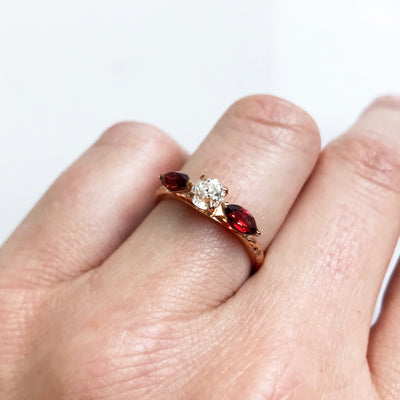Bespoke Craig ethical trilogy engagement ring, recycled old-cut diamond, fair-traded and conflict-free marquise-cut garnets and 18ct rose Fairmined Ecological Gold lifestyle
