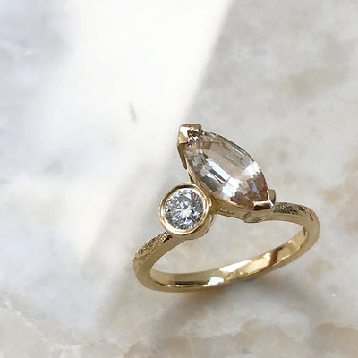 Bespoke Matt toi et moi engagement ring, champagne Sri Lankan marquise sapphire, recycled brilliant-cut diamond and 18ct yellow Fairtrade Gold lifestyle