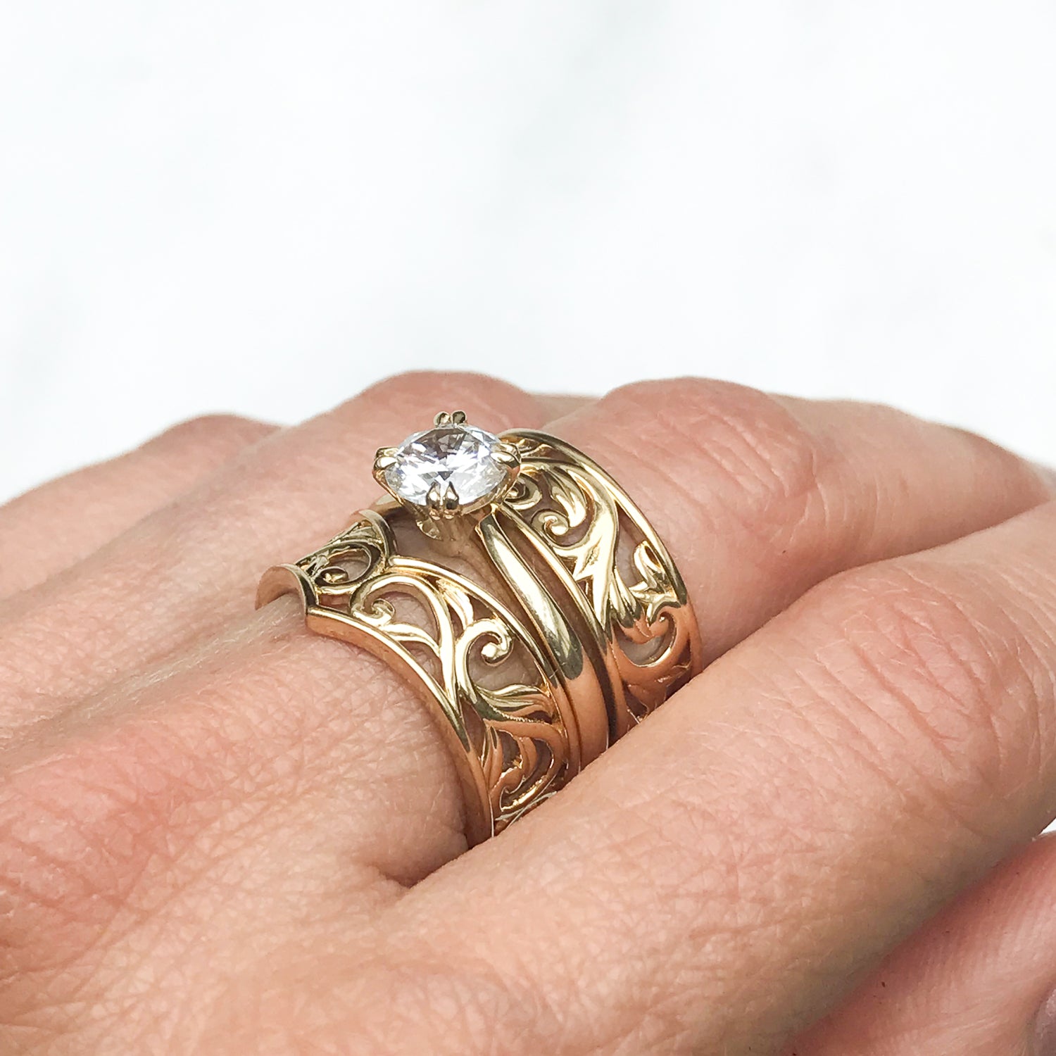 Artisan Filigree Ethical Gold Commitment Ring on hand, stacked with Artisan solitaire engagement ring and Filigree Artisan Wishbone ring, side 