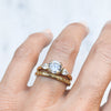 Lebrusan Studio Artisan Trilogy Engagement Ring, 1ct Ocean Diamond, 0.3ct pear-cut side Ocean Diamonds, 18ct Fairmined Ecological Gold, hand engraving, on hand, along with our hand-engraved Scrolls Ethical Gold Wedding Ring