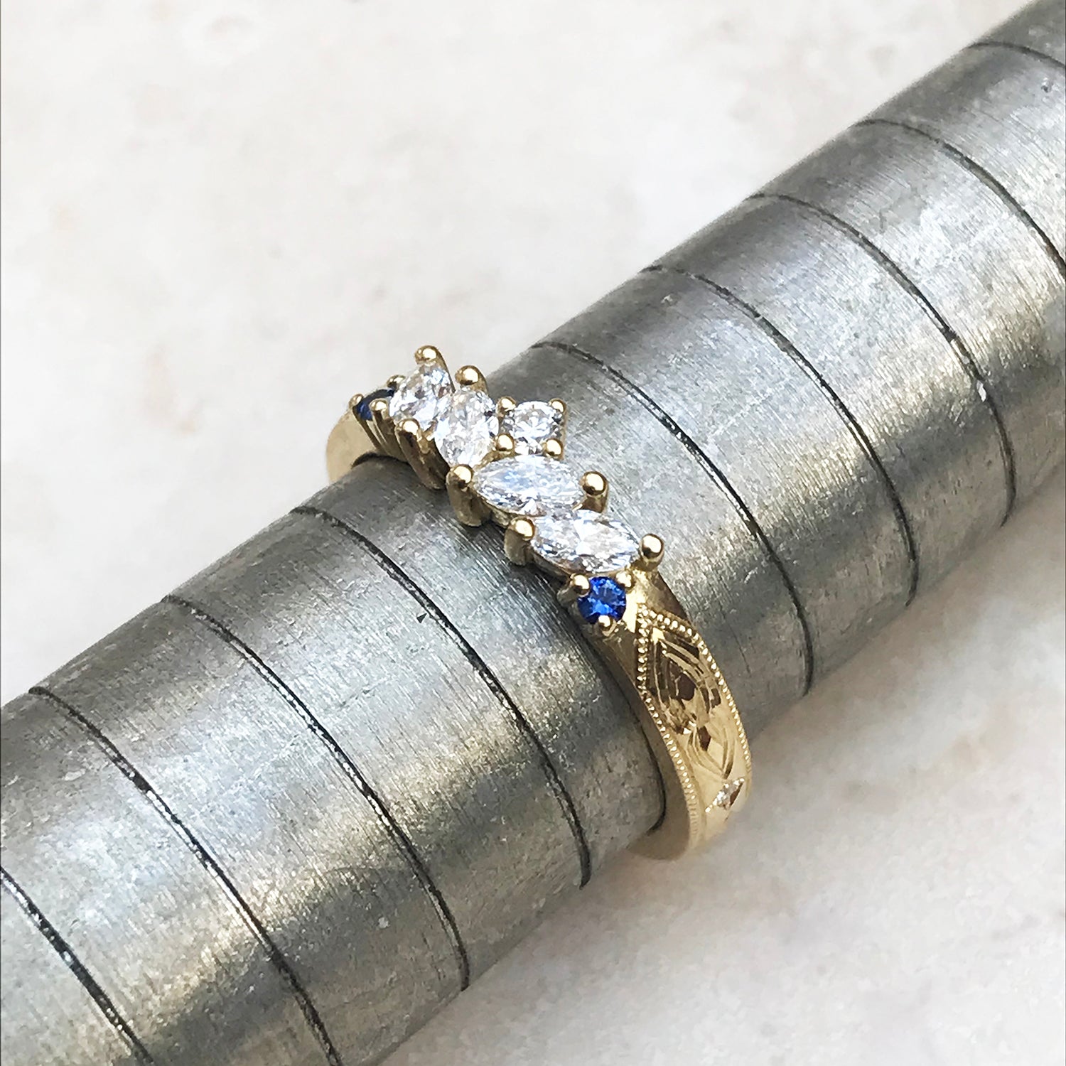 Louise Clarke bespoke hand-engraved wedding band, 18ct yellow Fairtrade Gold, marquise Canadian diamonds, artisanal Ocean Diamonds and fair-traded blue sapphires lifestyle 